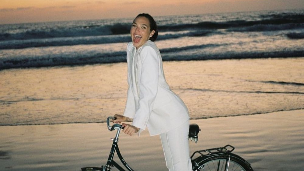 Tampil Elegan, Gal Gadot Bersepeda Di Pantai Pakai Pantsuit Putih